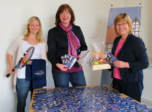 Das Foto zeigt von links: Paula Dangberg (Mitarbeiterin im Stadtmarketing, Bürgermeistern Anne Rodenbrock-Wesselmann und Anne Prell (städtisches Tourismusbüro), mit den drei Hauptpreisen und den Gewinnen für die Plätze vier bis zehn, ein Haller Wohlfühlhandtuch.