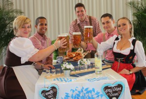 Das siebte Oktoberfest am 25. September im GERRY WEBER Event & Convention Center wirft seine Schatten voraus. Wies‘n-Wirt Kai Tiemer (mitte) serviert die Original Münchner Weißwürste und Brez’n. Mit einem Wies’n-Bier stoßen (von links) Lisa Scholtyssek, Jesse Beverly, Daniel Przystolik und Yasemin Ceyran auf einen zünftigen Abend an. © GERRY WEBER WOLRD (HalleWestfalen)