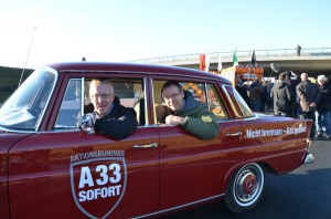 Nicht bremsen – Gas geben: Landrat Sven-Georg Adenauer (rechts) und Michael zur Heiden kamen mit einem roten Merce-des-Oldtimer zur Eröffnung des Teilabschnittes.