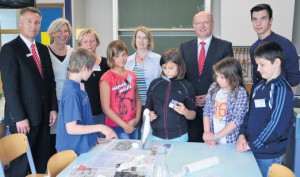 Wie das Ei unzerstört durch den Flaschenhals kommt: Das fasziniert die Fünftklässler – von links: Joshua, Alida, Lilli, Jennifer und Niklas mehr als die Kamera des Fotografen. In der hinteren Reihe – von links: Guntram Boers, Ursula Husemann, Ute Sartorius, Dr. Annette Mix, Hartwig Mathmann und Frederic Bussemas. Foto: A. Großpietsch