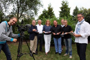 Kameramann Matthias Cremer (filmanufaktur) und Produzent Timo Klack (rechts außen mit Block, KontextKontor) bei einer Drehbuchbesprechung mit Vertretern von Förderverein und Stadt HalleWestfalen (von links), dies sind Frank Hofen (Gerry Weber World), Detlef Wemhöner (Technische Werke Osning), Bürgermeisterin Anne Rodenbrock-Wesselmann, Michael Schoregge (Vorsitzender Haller Interessen- und Werbegemeinschaft), Andy Marten (Landhotel Jäckel) und Olaf Sorge (Stadtmarketing).