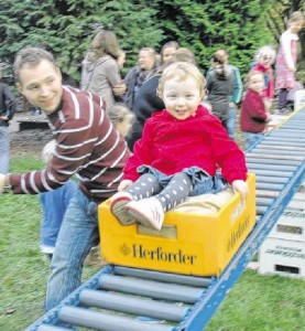   Jouline(2) genießt die Geschwindigkeit auf einemdicken Kissen in der Bierkiste. Ihr Vater Dennis Rösner läuft nebenher. FOTOS: E. HUFENDIEK